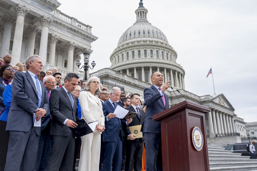 Hakeen Jeffries speaks on a podium outside of the Capitol