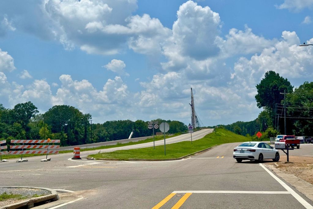 A bridge road on the left blocked by orange barriers