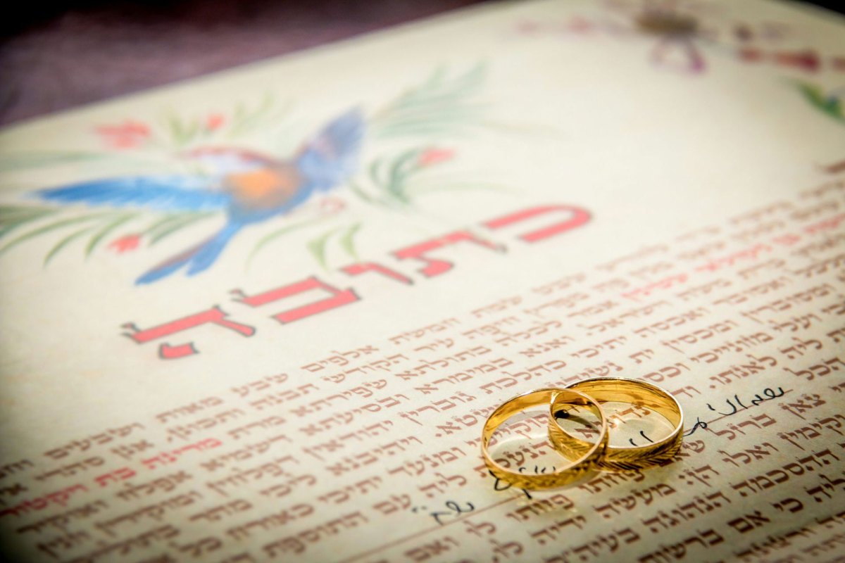 Two wedding rings on top of a marriage contract