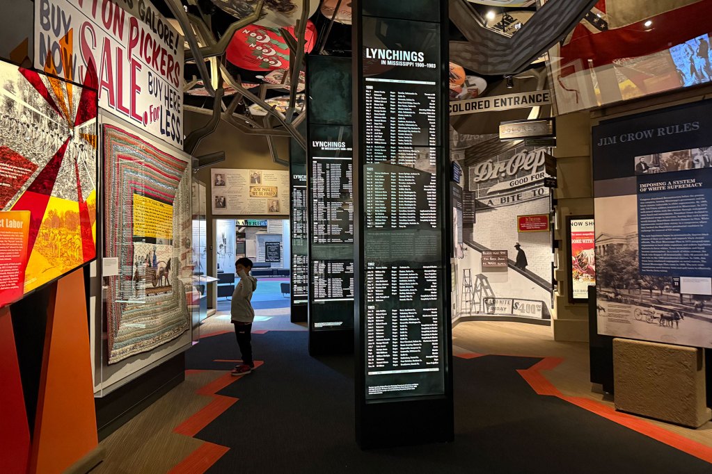 A person stands inside a visually exciting civil rights museum