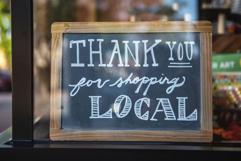 A hand written sign in a window reads Thank you For Shopping Local