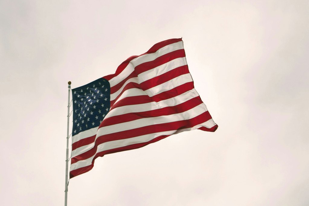 The US Flag waving in the air on a poll