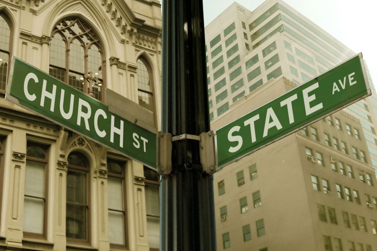 A street sign on a light post indicating the cover of Church Street and State Avenue