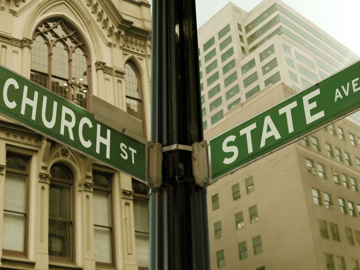 A street sign on a light post indicating the cover of Church Street and State Avenue