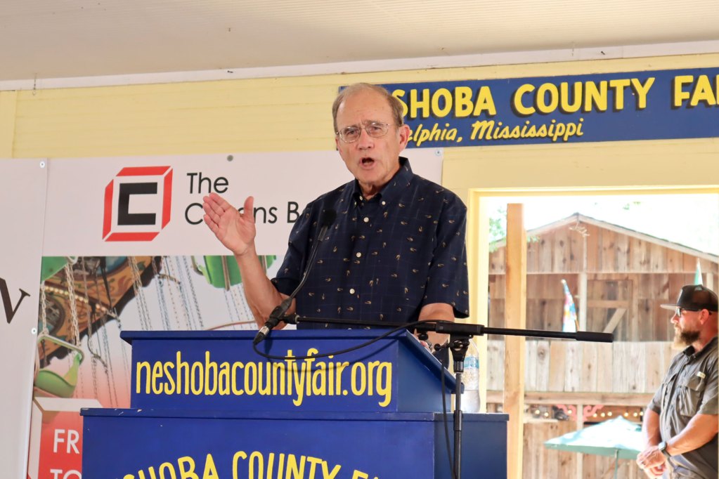 Delbert Hosemann stands behind a podium and speaks into a microphone at the Neshoba County Fair.