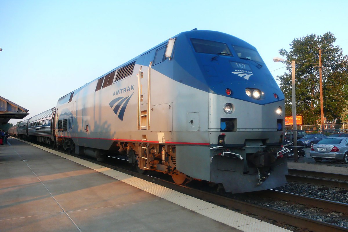A blue and silver Amtrak train sitting at a station