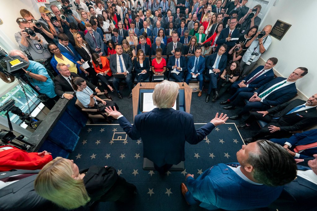 An overhead rear view of Donald Trump speaking in the White House press room
