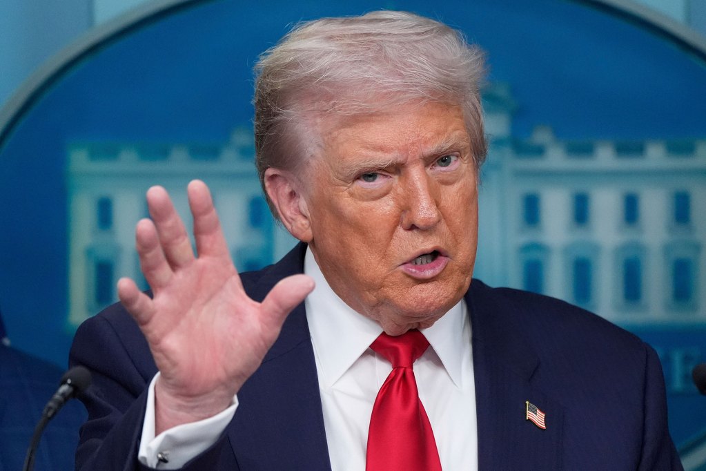 Donald Trump speaks in a press conference, hand gesturing wide