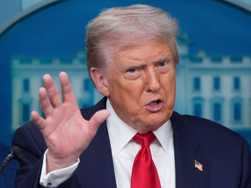 Donald Trump speaks in a press conference, hand gesturing wide