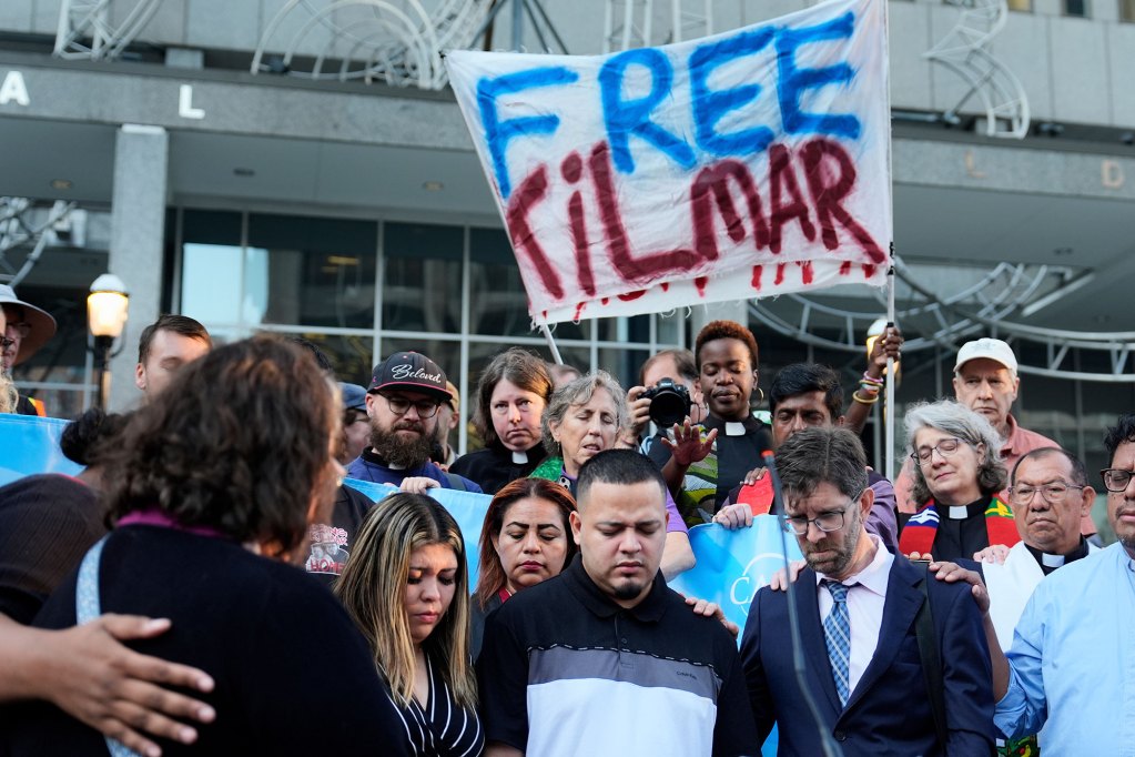 Kilmar Abrego Garcia and his wife Jennifer stand in front of a group at a rally