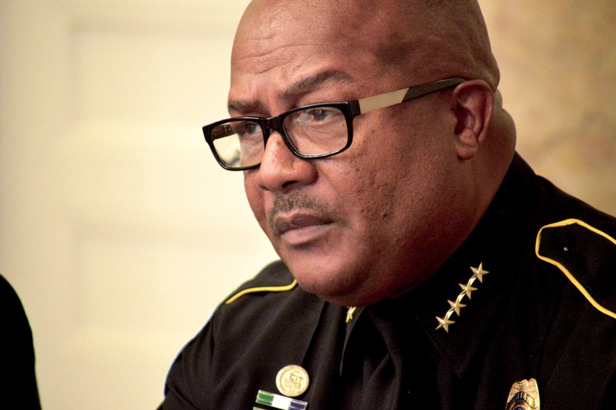 Chief Police officer at a meeting talking with media.