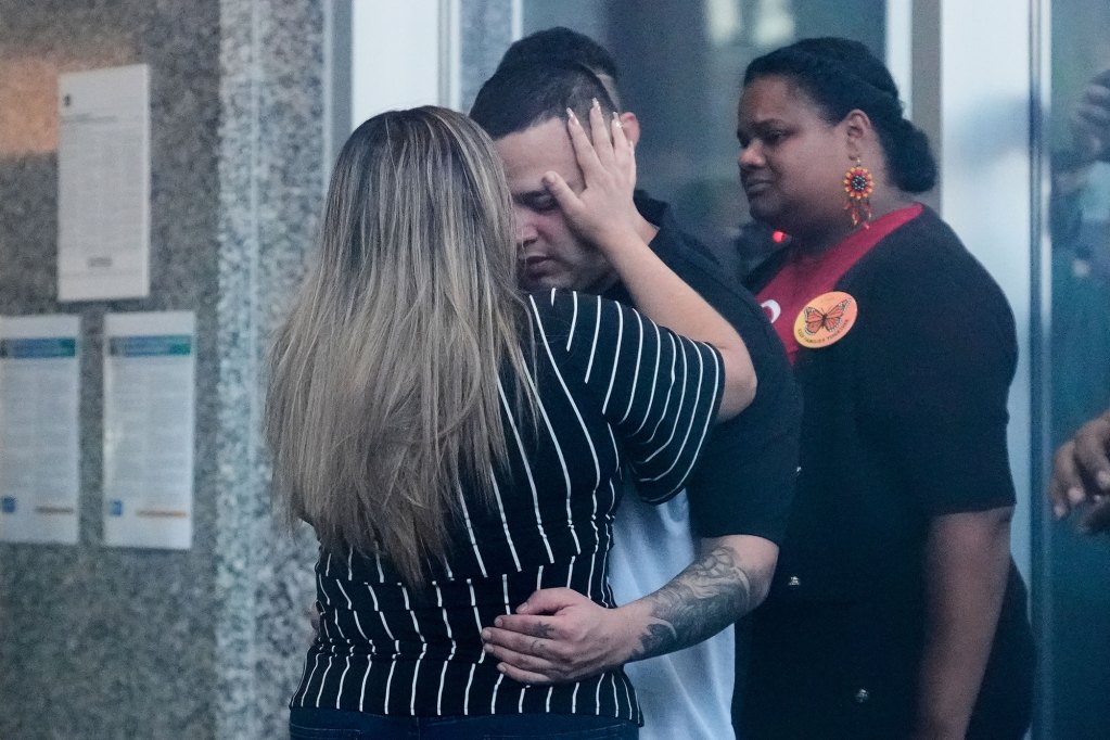 A husband and wife hug outside