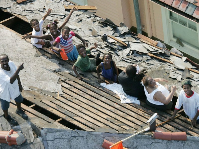 Nine people wait a rescue on a flood damaged roof