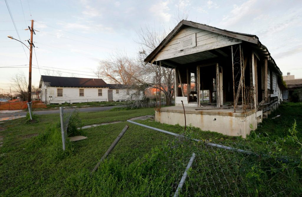 A house missing it walls and with a torn-down fence