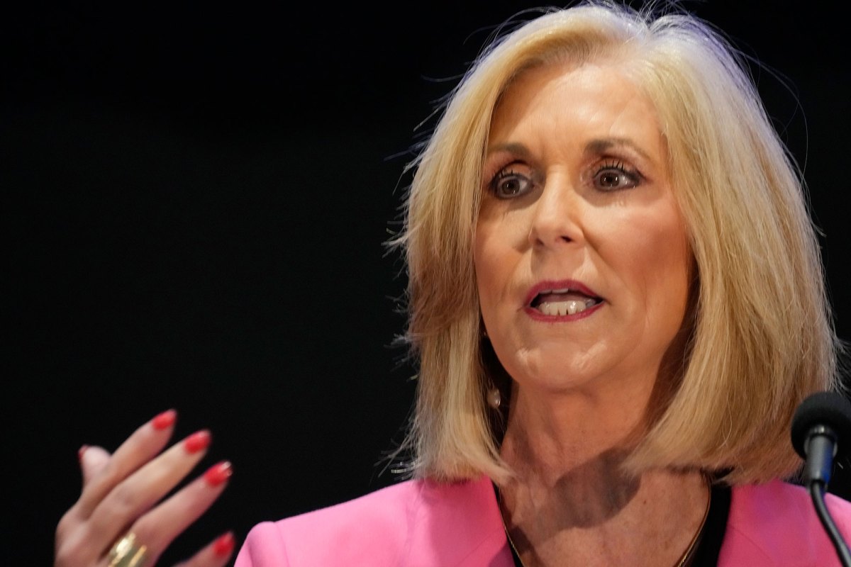 Closeup of Lynn Fitch, in a pink suit, speaking at a mic