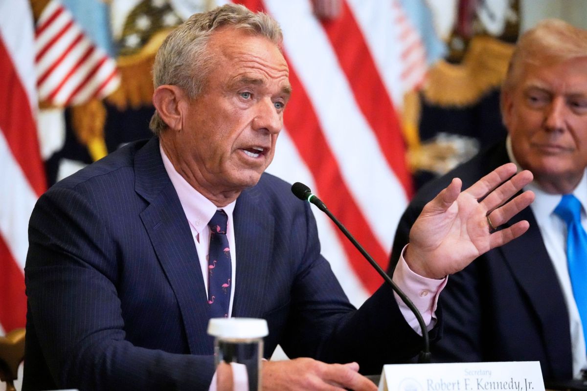 Robert F. Kennedy Jr. speaking at a press conference, with Donald Trump beside him