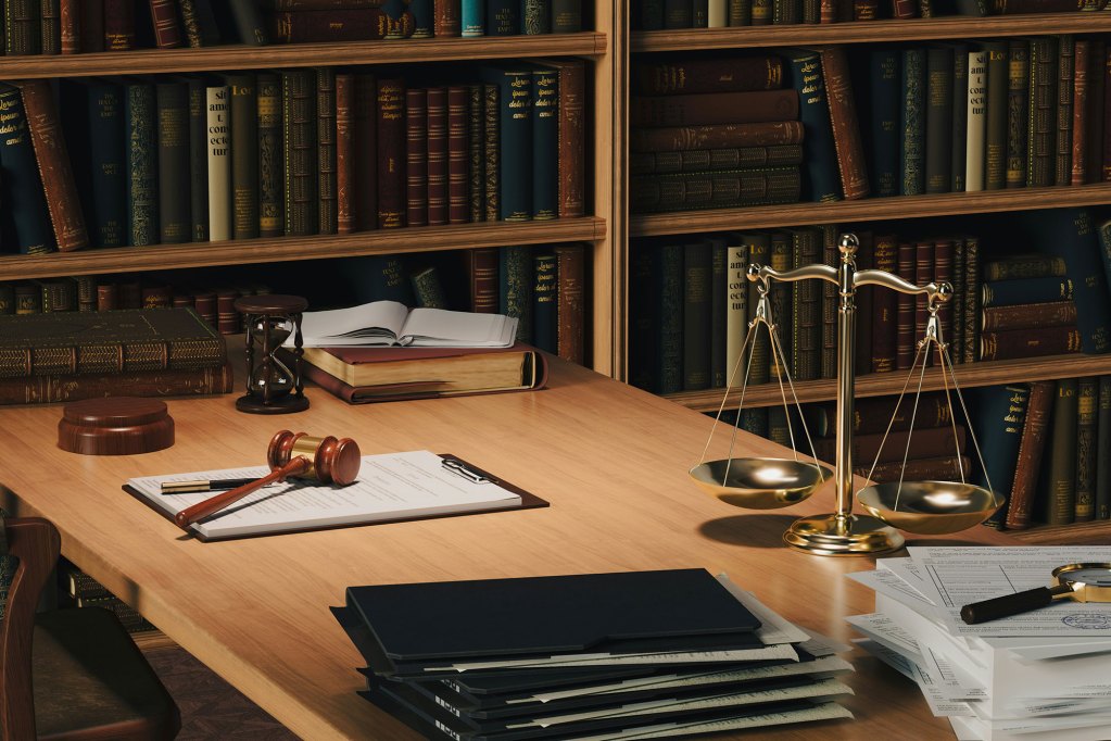 A 3D render of a legal room with bookshelves behind a desk filled with paperwork, scales and a gavel