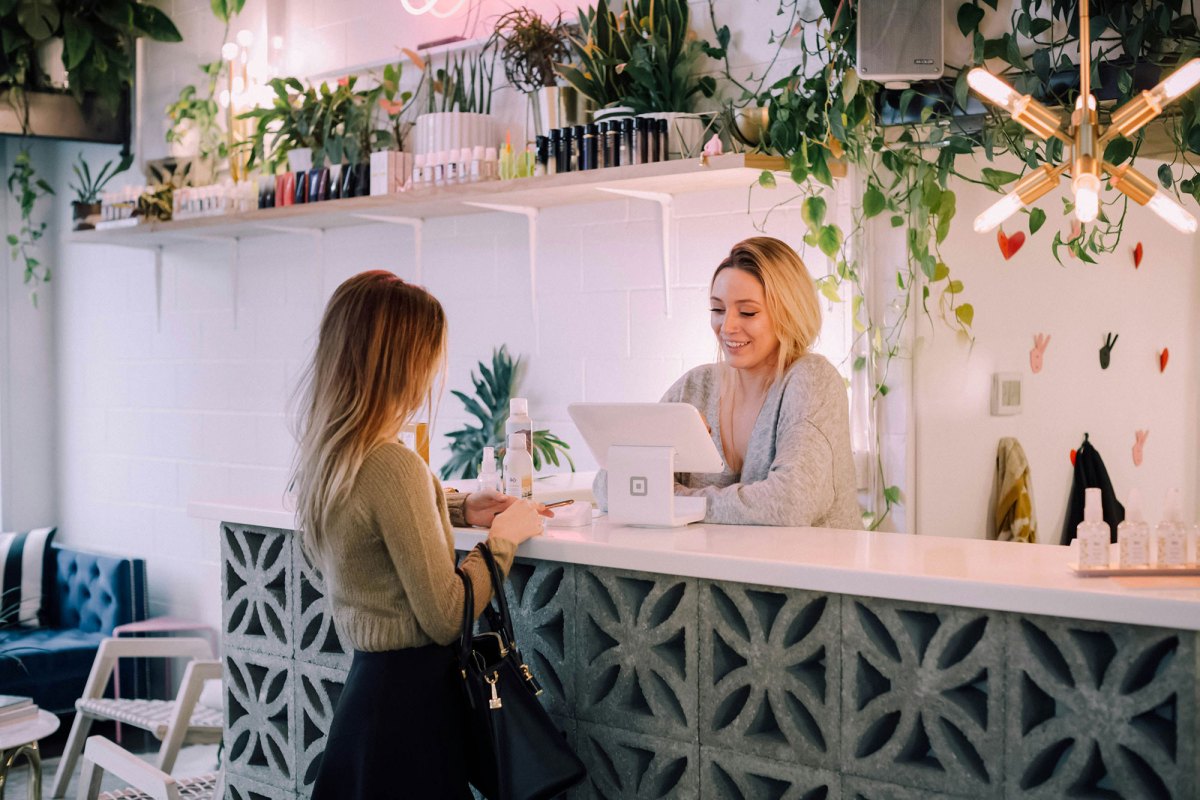 A woman checks out a customer at a tablet register