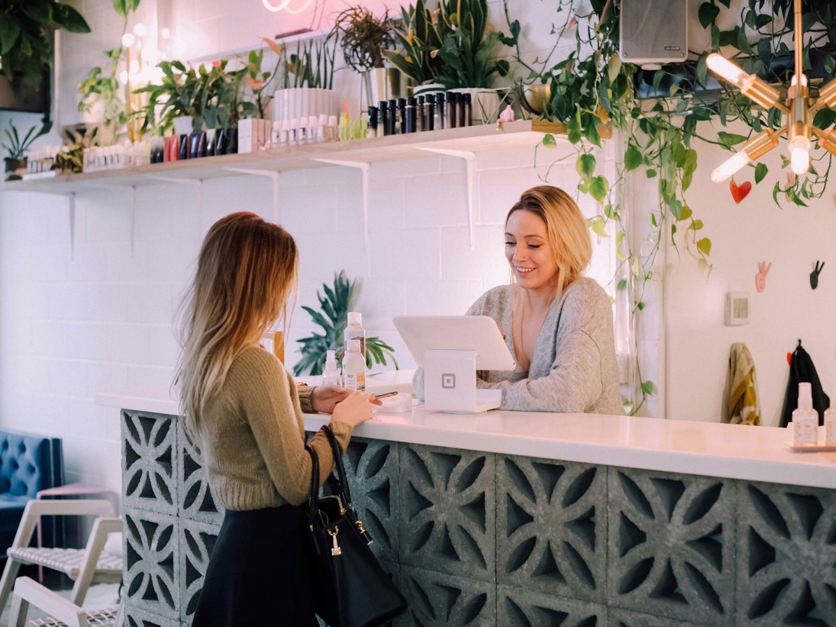 A woman checks out a customer at a tablet register