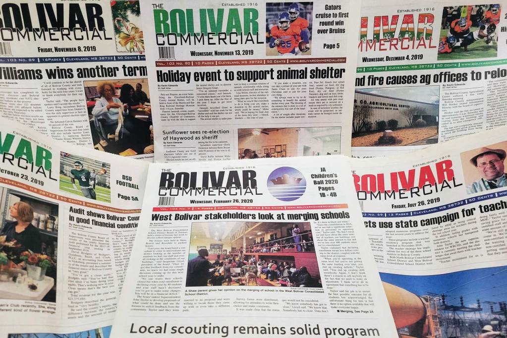 Several editions of The Bolivar Commercial newspaper on display.