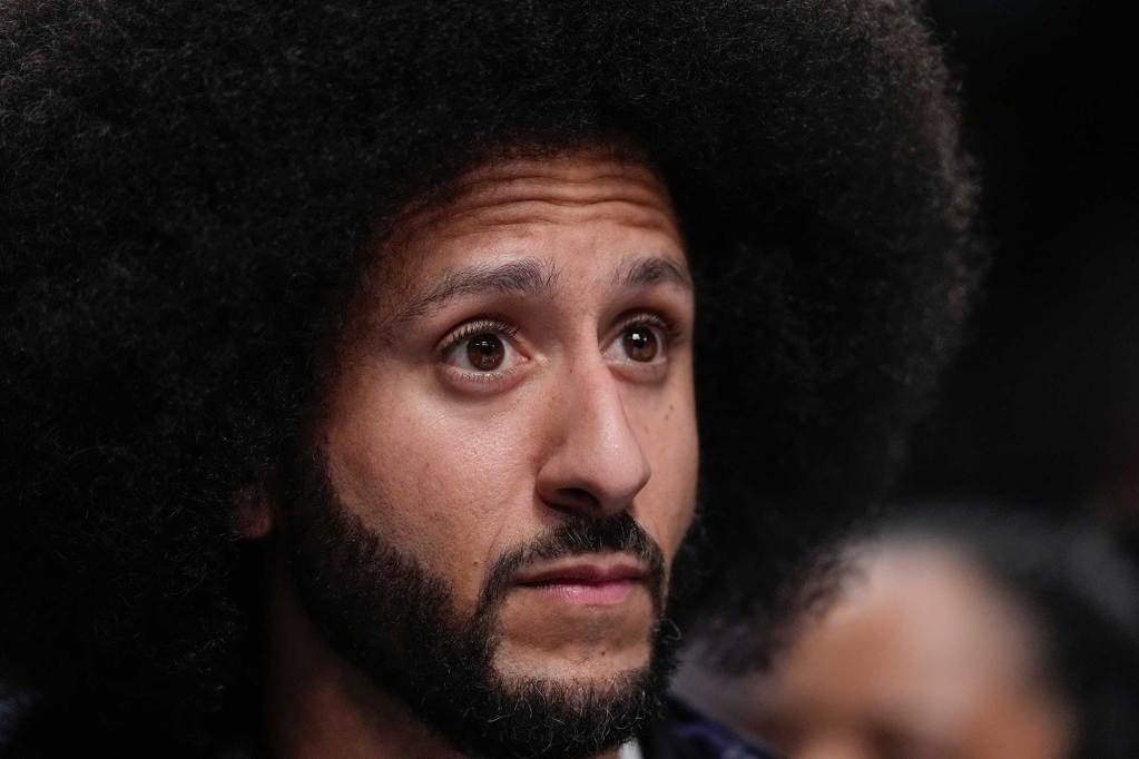 A closeup of Colin Kaepernick watching intently