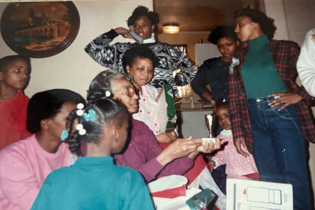 A family photo taken inside the hope with any family members standing around and talking
