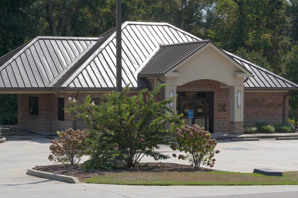 A brick office building with a brown metal roof with the words “North Lamar Water Association” on the wall.