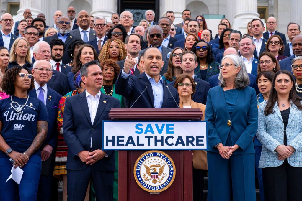Hakeem Jeffries speaks at a podium labeled SAVE HEALTHCARE
