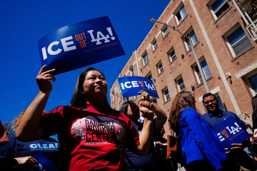Several protestors hold signs that read 'ICE OUT OF LA'