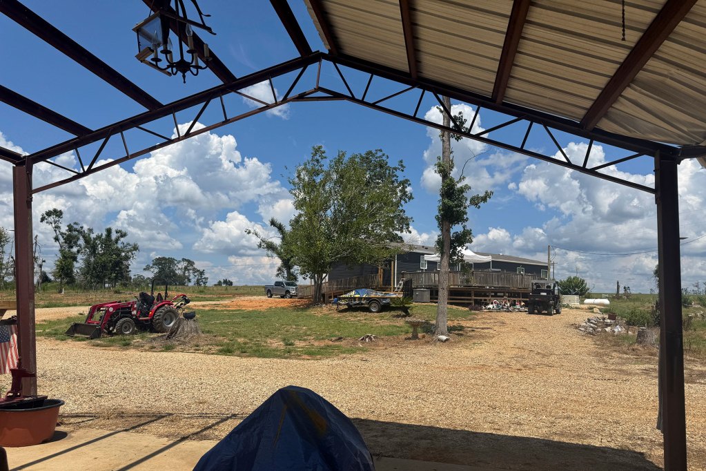 A view from a tornado damaged carport and onto a home on the other end of the driveway