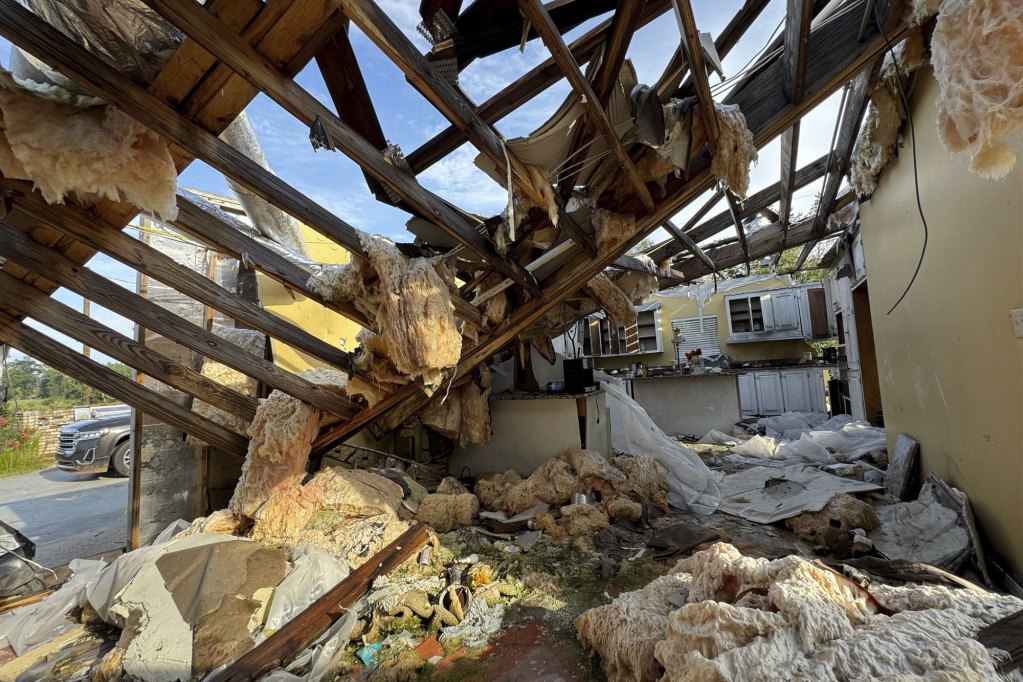 An interior view of a tornado damaged home, roof frame fallen into the home