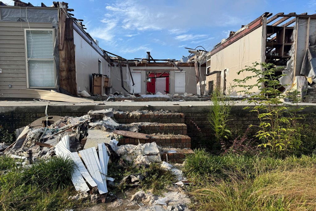 A view into a home destroyed by a tornado, roof and entryway wall entirely missing
