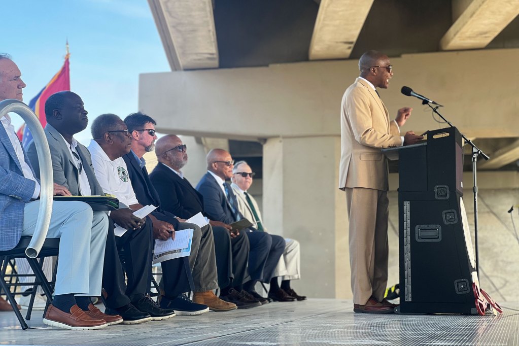 Errick Simmons speaks at a press conference held during the day under a bridge