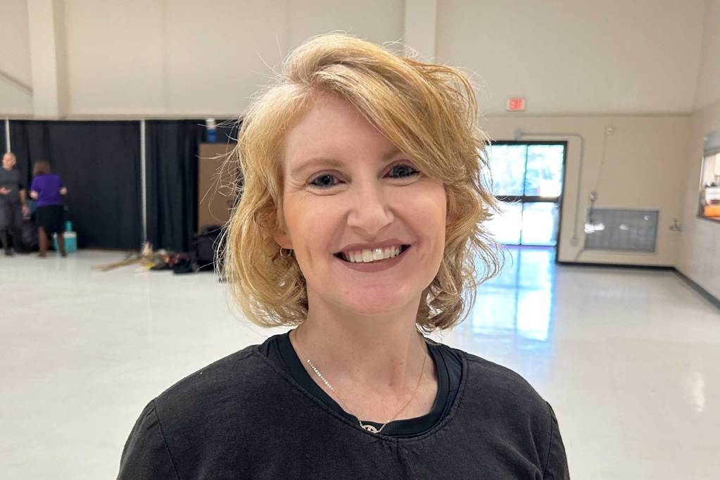 A blonde woman smiles for a photo