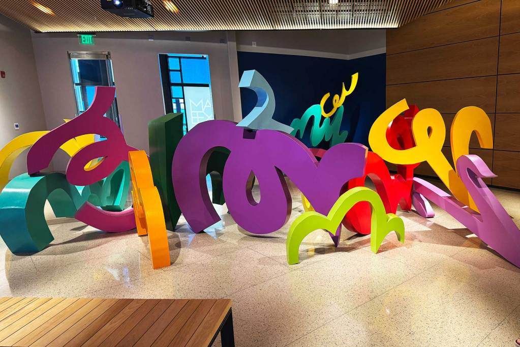 Large colorful forms take up a large amount of floor space in a museum exhibit