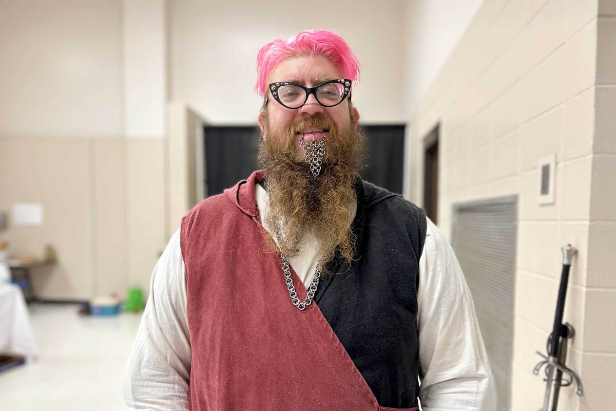 A person with pink and brown hair and chainmail hanging from their lip