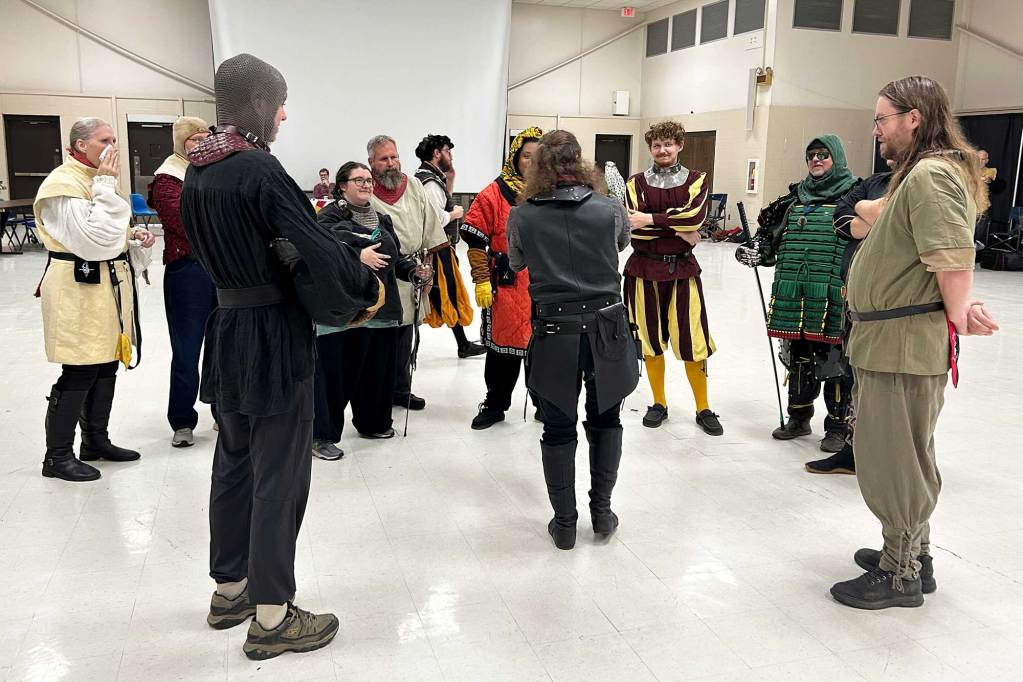 People in various dress stand around in a semicircle before practice
