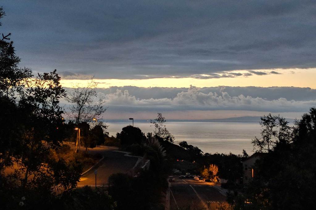 A sunrise over a neighborhood set in the hills