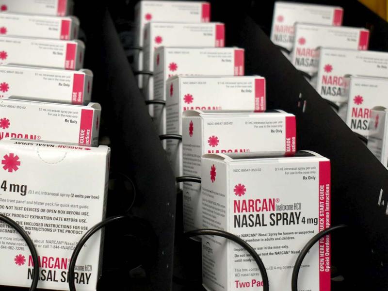 White and red packages of Narcan inside a vending machine.