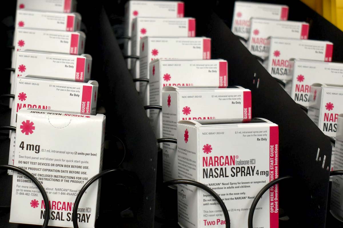 White and red packages of Narcan inside a vending machine.