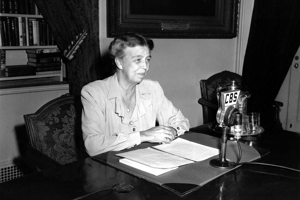 Eleanor Roosevelt sits at a desk in the White House and speaks in to a CBS mic in this black and white photo from 1944