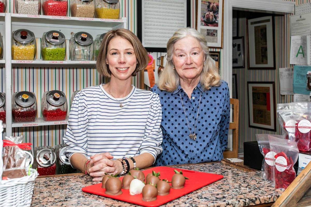 Emmie and Nancy King stand together behind the counter of their candy store
