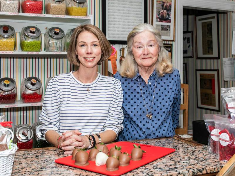 Emmie and Nancy King stand together behind the counter of their candy store