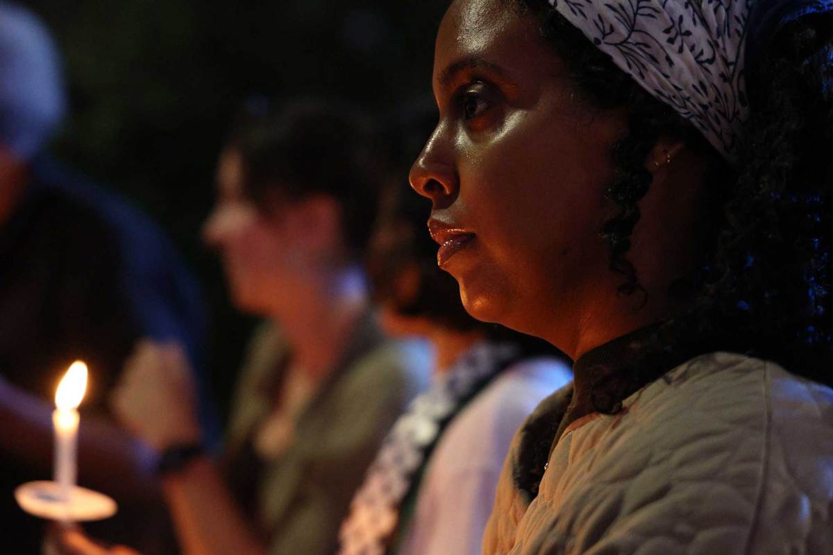 People hold a candlelight vigil at night