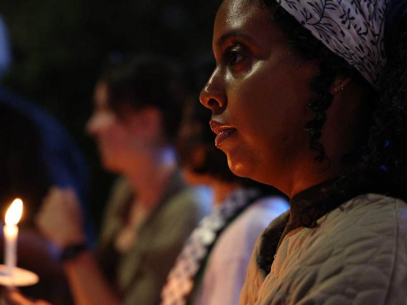 People hold a candlelight vigil at night