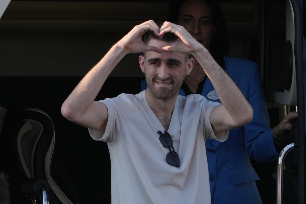 a man holds his hands up in the shape of a heart
