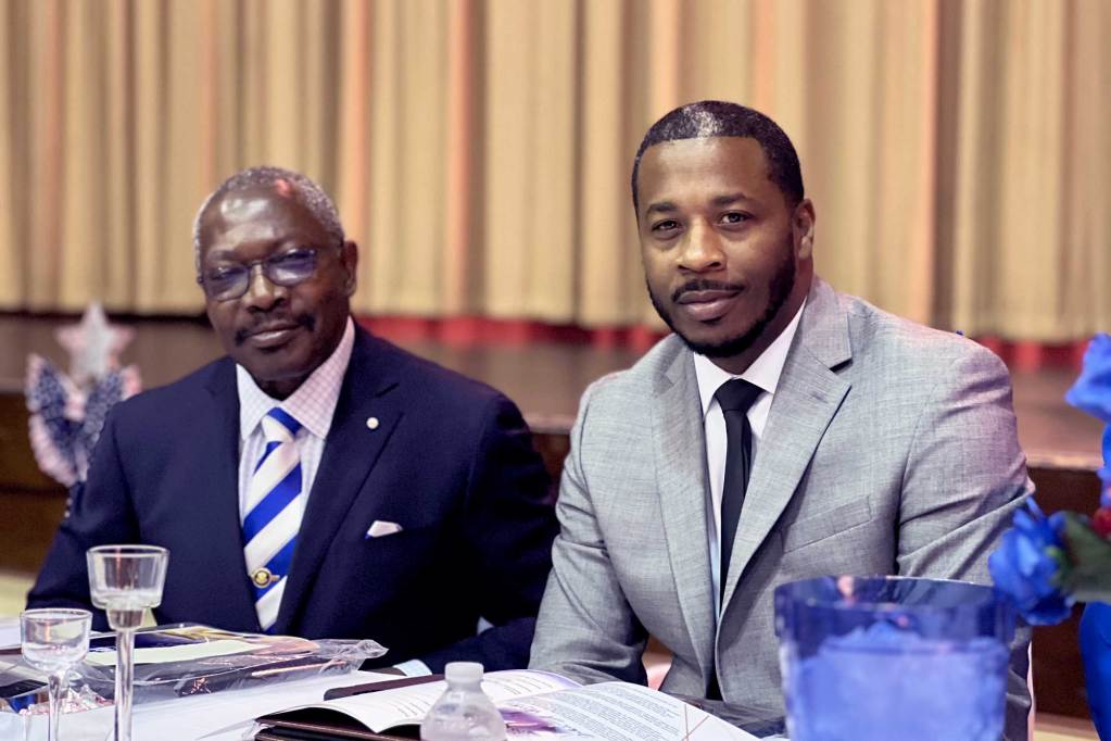 John Horhn and Kenderick Cox sit together at a banquet table