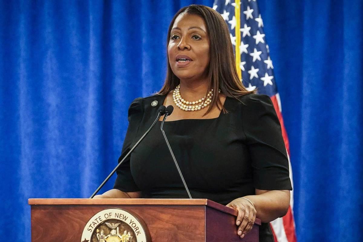 A Black woman with long, dark hair speaking behind a podium