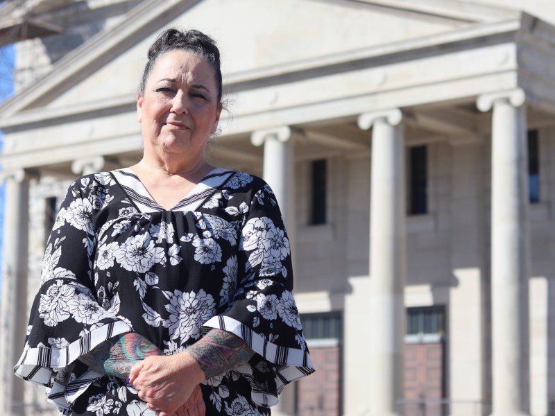 a woman stands in front of the Mississippi Supreme Court with her hands clasped