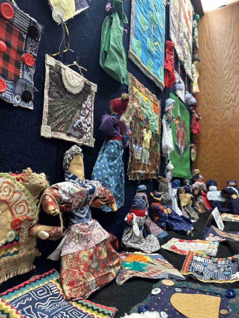 An assortment of fiber arts and handmade dolls